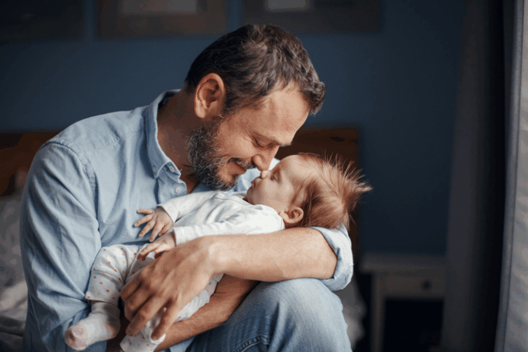 Father holding his baby, representing the importance of men’s health and fertility.