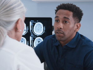 man talking to doctor about brain scan about possible concussion after car accident