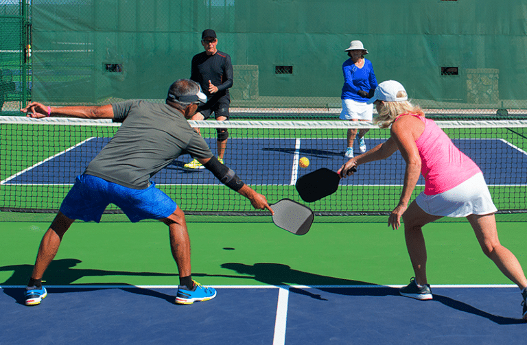 Pickleball players on court illustrating common pickleball injuries treated at Momentum Medical Central Florida